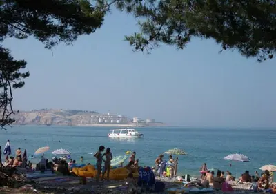 a group of people on a beach with a boat in the water at Studios Zoran Milosev in Bar