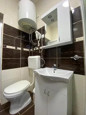 a bathroom with a white toilet and a sink at Studios Zoran Milosev in Bar