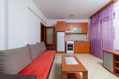 a living room with a couch and a kitchen at Apartmani Jovan in Budva