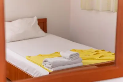 a mirror reflection of a bed with towels on it at Apartmani Jovan in Budva