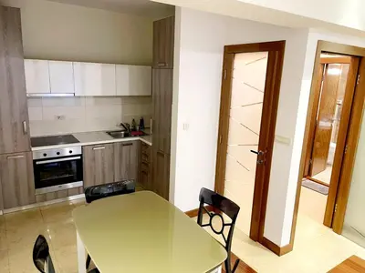 a kitchen with a table and a table and chairs at City center apartment in Podgorica