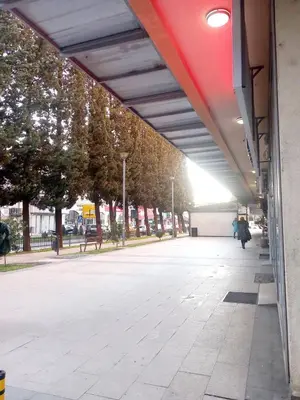 a person walking down a sidewalk next to a building at City center apartment in Podgorica