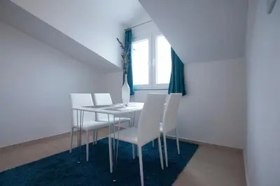 a dining room with a table and white chairs at Apartments Kuljace in Sveti Stefan