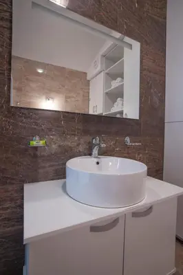 a bathroom with a white sink and a mirror at Apartments Kuljace in Sveti Stefan
