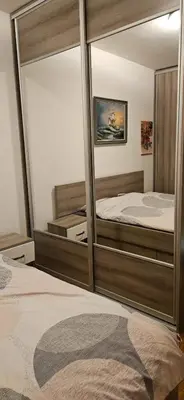 a bedroom with two beds and a large mirror at City kvart apartment in Podgorica