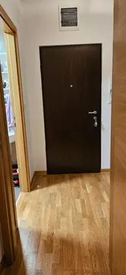 a black door in a room with a wooden floor at City kvart apartment in Podgorica