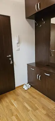a room with a kitchen with a wooden floor and a door at City kvart apartment in Podgorica