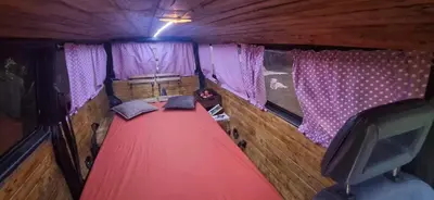 an inside view of a room with a red carpet and curtains at Camper t4 in Danilovgrad