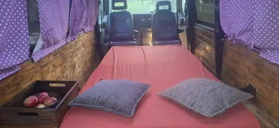 a bed in the back of a bus with a box of apples at Camper t4 in Danilovgrad