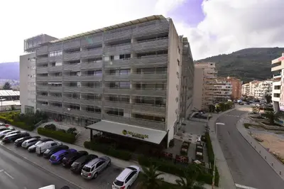 a large building with cars parked in a parking lot at Marilyn Apartment in Budva