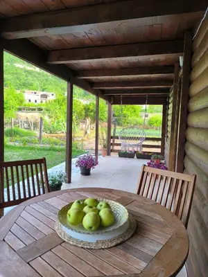 a wooden table with a bowl of apples on it at Wooden Lakeside Cottage in Virpazar