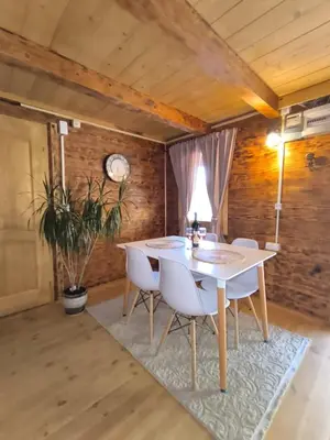 a dining room with a white table and chairs at Wooden Lakeside Cottage in Virpazar