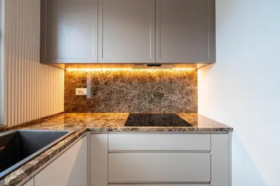 a kitchen with white cabinets and a counter top at Villa Del Sol in Budva