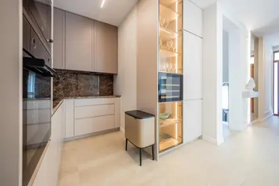 a kitchen with white cabinets and a black stool at Villa Del Sol in Budva