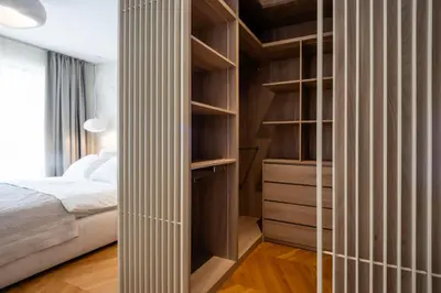 a bedroom with a bed and a large closet at Villa Del Sol in Budva