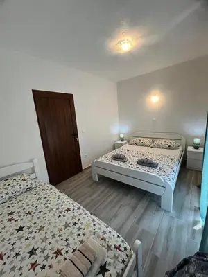 a bedroom with two beds and a door in it at More i Vuk in Bar