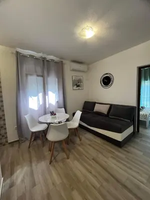 a living room with a bed and a table and chairs at More i Vuk in Bar