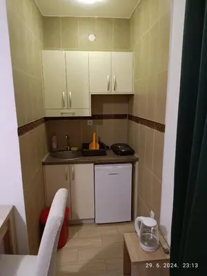 a small kitchen with white cabinets and a sink at More i Vuk in Bar