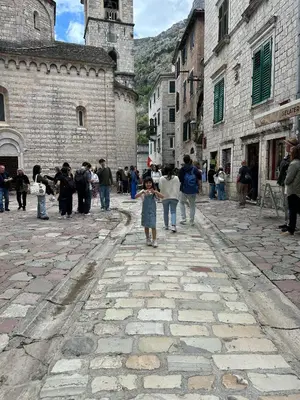 a little girl walking down a cobblestone street at levent 2 in Kotor