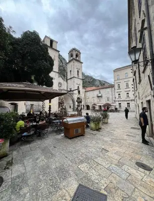 a group of people sitting at tables in a courtyard at levent 2 in Kotor