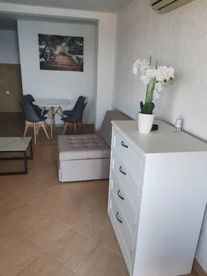 a living room with a white dresser with flowers on it at Villa Contact in Dobra Voda