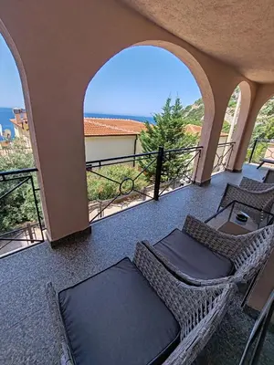 a balcony with two chairs and a table at Villa Contact in Dobra Voda