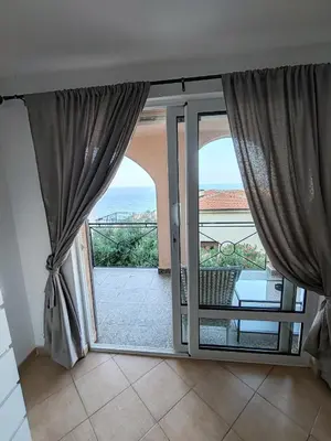 an open door to a balcony with a view of the ocean at Villa Contact in Dobra Voda