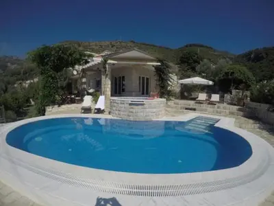 a large swimming pool in front of a house at Villa Royal Dream in Sveti Stefan