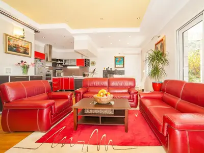 a living room with red leather furniture and a table at Villa Royal Dream in Sveti Stefan