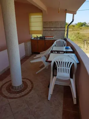 a patio with two white chairs and a table at Family Apartments Pepic in Ulcinj