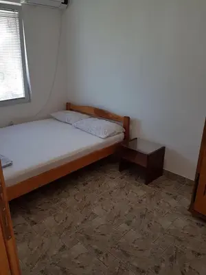 a small bedroom with a bed and a table at Family Apartments Pepic in Ulcinj