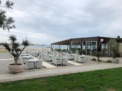 a row of white tables and chairs in front of a building at Apartment Marina in Bar