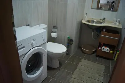 a bathroom with a washing machine and a sink at Apartment Marina in Bar