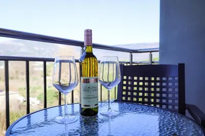 a bottle of wine sitting on a table with two wine glasses at Apartman Zorana in Tivat