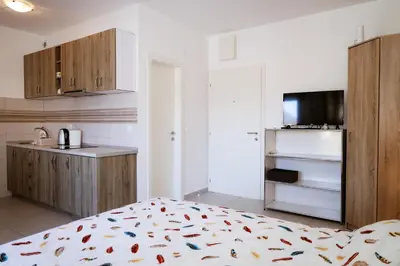 a bedroom with a bed and a kitchen with a counter at Apartman Zorana in Tivat