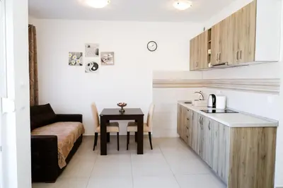 a kitchen with a table and a couch in a room at Apartman Zorana in Tivat