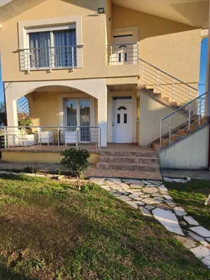 a house with stairs and a porch with a balcony at Apartments Donja Gorica in Podgorica