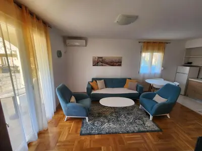 a living room with a couch and a table and chairs at Apartments Donja Gorica in Podgorica