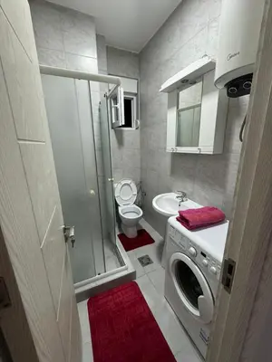 a bathroom with a washing machine and a toilet at N&J apartman in Podgorica