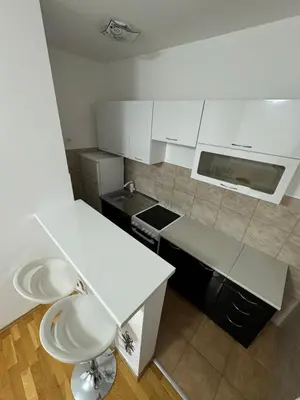a white kitchen with a counter and a sink at N&J apartman in Podgorica