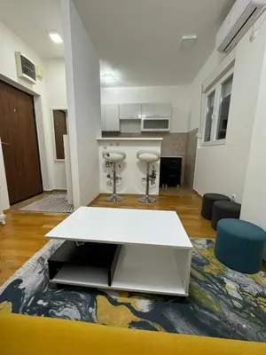 a living room with a white table and chairs at N&J apartman in Podgorica