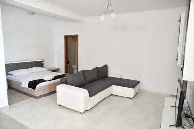 a bedroom with a bed and a white couch at Casa Bianca 1 in Ulcinj