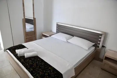 a bedroom with a bed with two pillows and a mirror at Casa Bianca 1 in Ulcinj