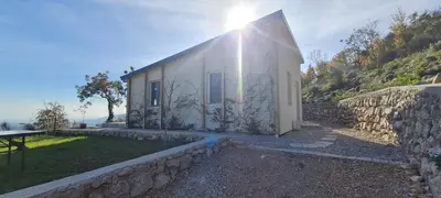 a house with a stone wall next to a building at Sunrise Lodge in Dapčevići