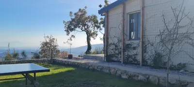 a table in the grass next to a building at Sunrise Lodge in Dapčevići