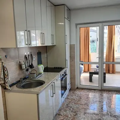 a kitchen with a sink and a sliding glass door at Vinogradi in Budva