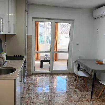 a kitchen with a door leading to a patio at Vinogradi in Budva