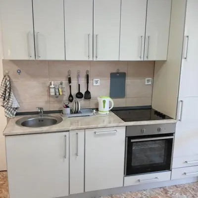 a kitchen with white cabinets and a sink at Vinogradi in Budva