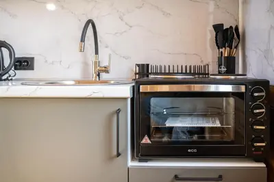a microwave oven in a kitchen next to a sink at RAOS Cottage in Ulcinj