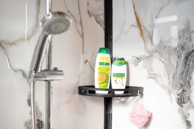 a shelf in a bathroom with toothpaste and a shower at RAOS Cottage in Ulcinj